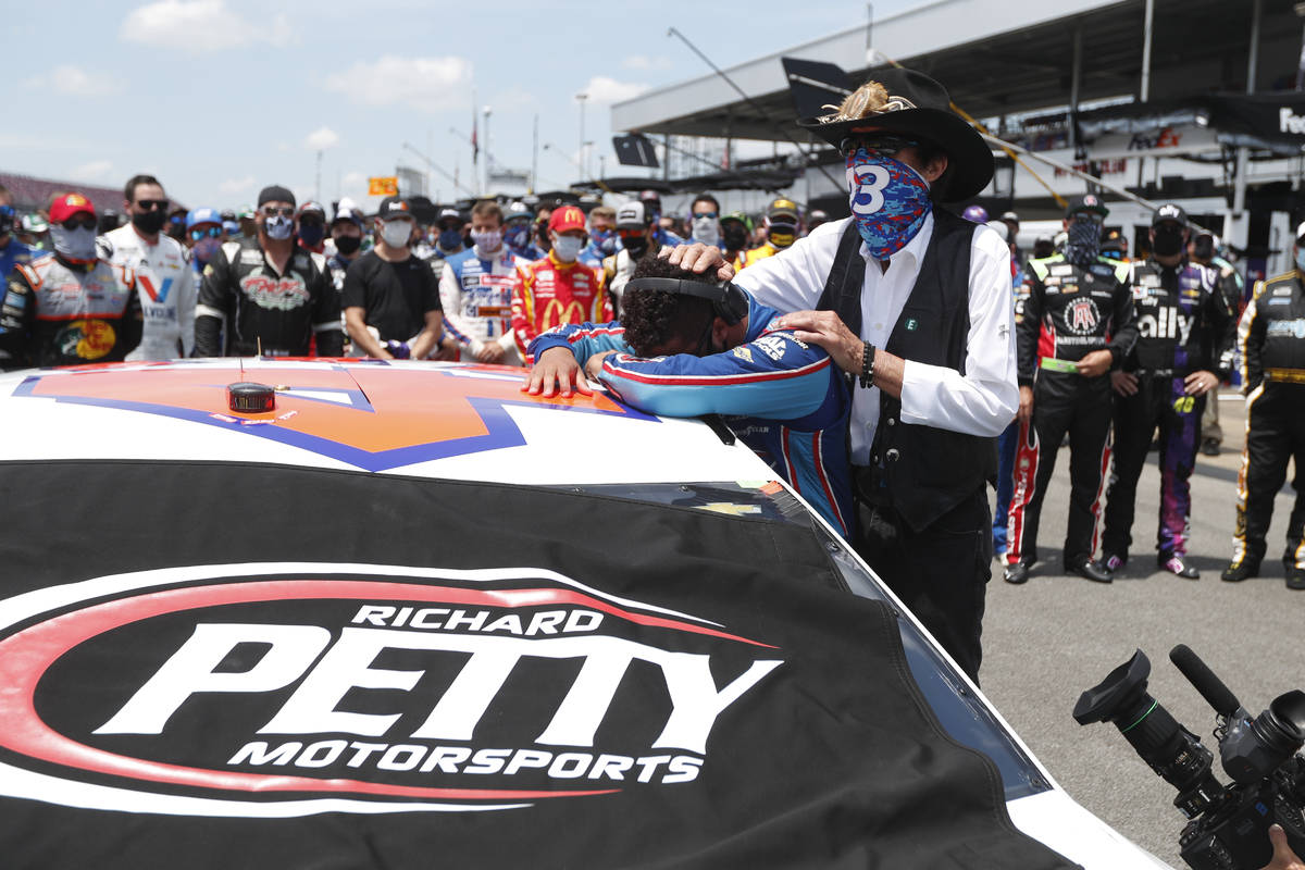 Driver Bubba Wallace, left, is overcome with emotion as team owner Richard Petty, comforts him ...