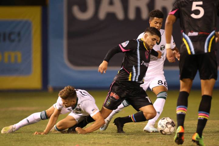 Las Vegas Lights FC forward Irvin Parra (11, center) is taken down by Portland Timbers 2 forwar ...