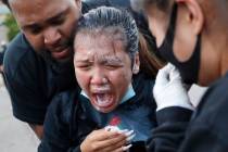 A woman is helped after being hit with pepper spray after curfew in Minneapolis. (AP Photo/John ...