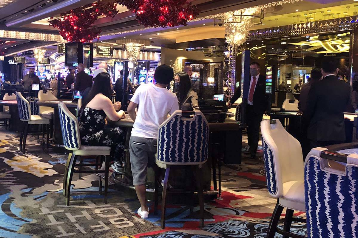 Gamblers sit three to a table at the Cosmopolitan of Las Vegas on Thursday, June 4, 2020. (Bria ...