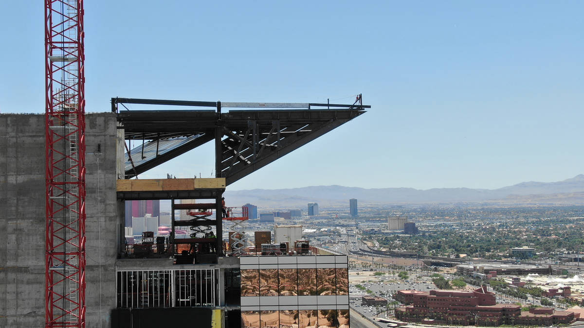 A white painted steel beam sits along the upper side of a triangular extension as the final top ...