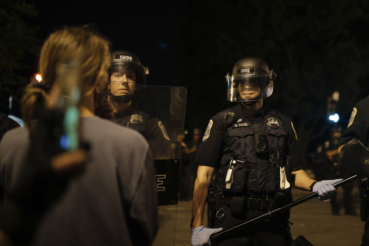Police form a security line after protesters tried to topple a statue of Andrew Jackson in Lafa ...