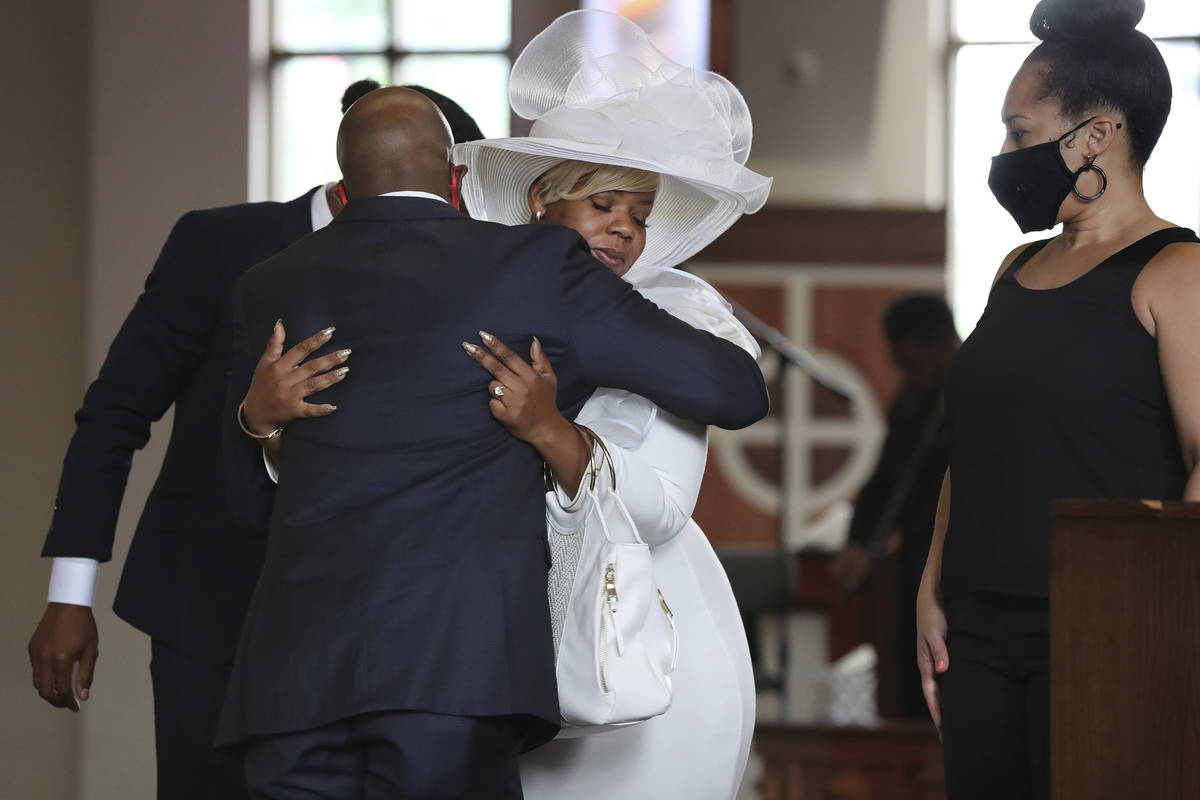The Rev. Raphael G. Warnock, senior pastor of Ebenezer Baptist Church, comforts Tomika Miller, ...