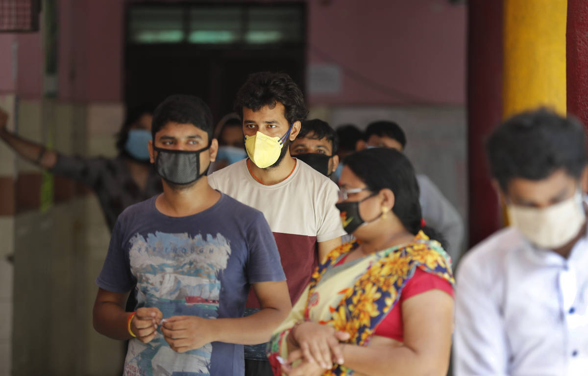 People wait in a queue for the COVID-19 rapid antigen test in New Delhi, India, Wednesday, June ...