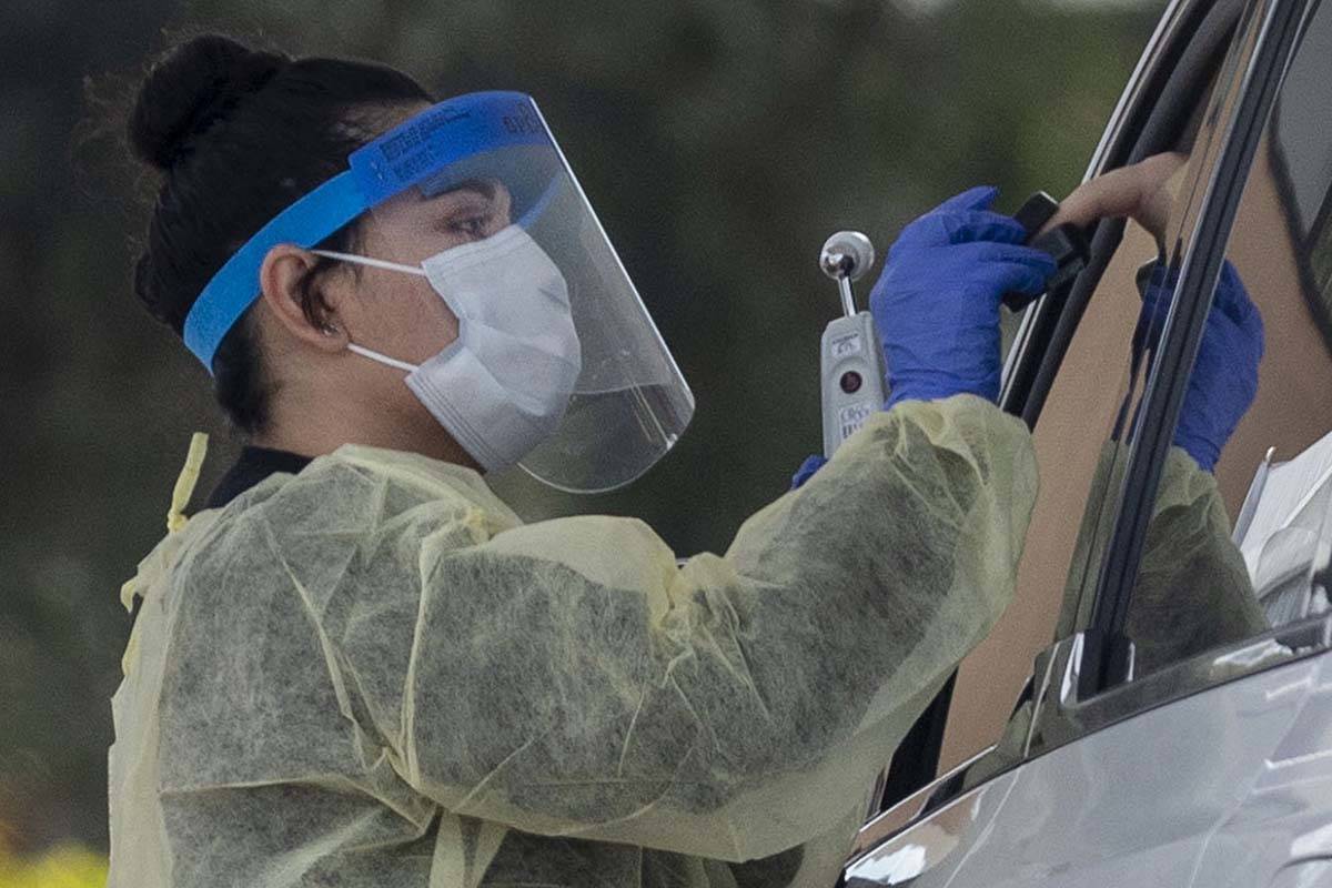 A UNLV medicine medical professional conducts a curbside test on a patient experiencing coronav ...