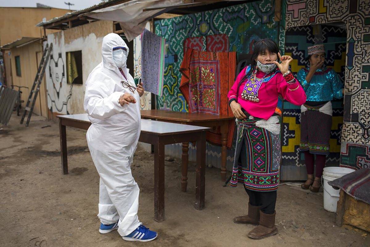 Olinda Silvano from the Shipibo Conibo ethnic group, talks to a member of an NGO dressed in pro ...