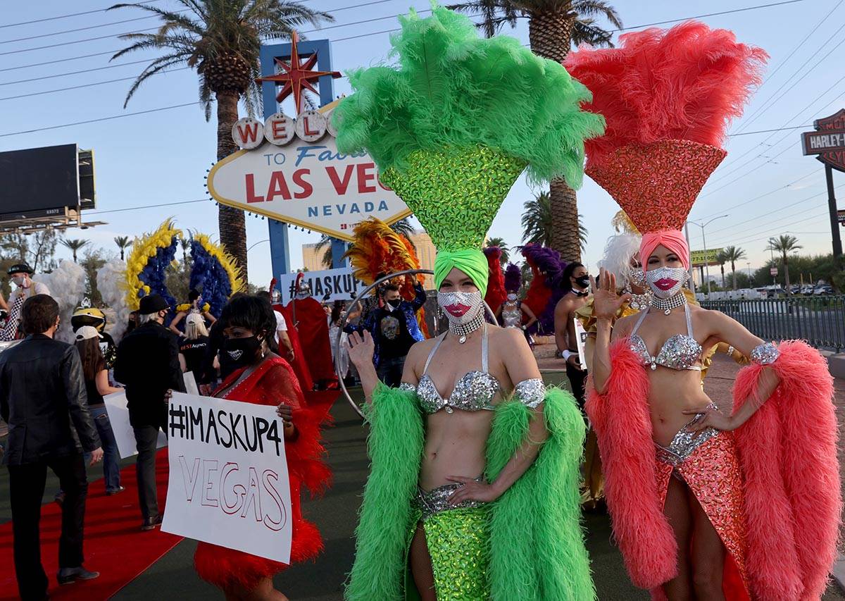 Showgirls and entertainers pose at the Welcome to Fabulous Las Vegas sign on the south Strip in ...