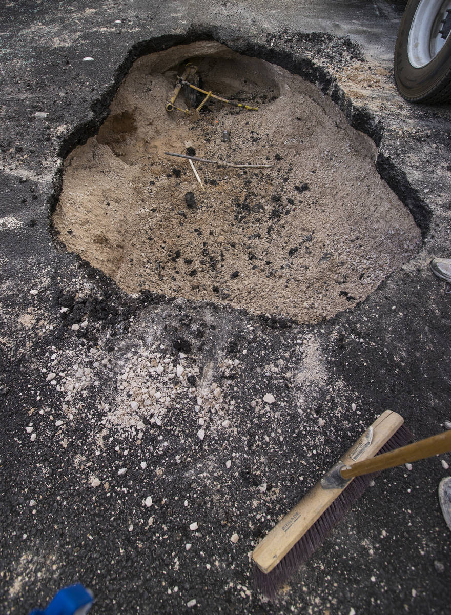 Las Vegas Valley Water District workers assess the damage from a sinkhole which opened up and d ...