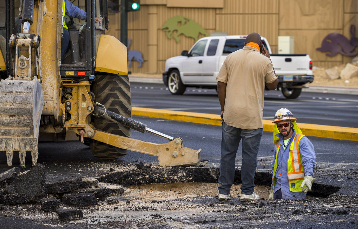 Las Vegas Valley Water District workers repair a sinkhole which opened up and damaged vehicles ...