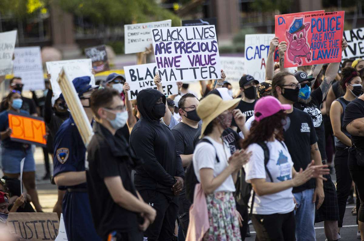 People hold up signs during a Black Lives Matter rally at the Sawyer Building in Las Vegas on F ...