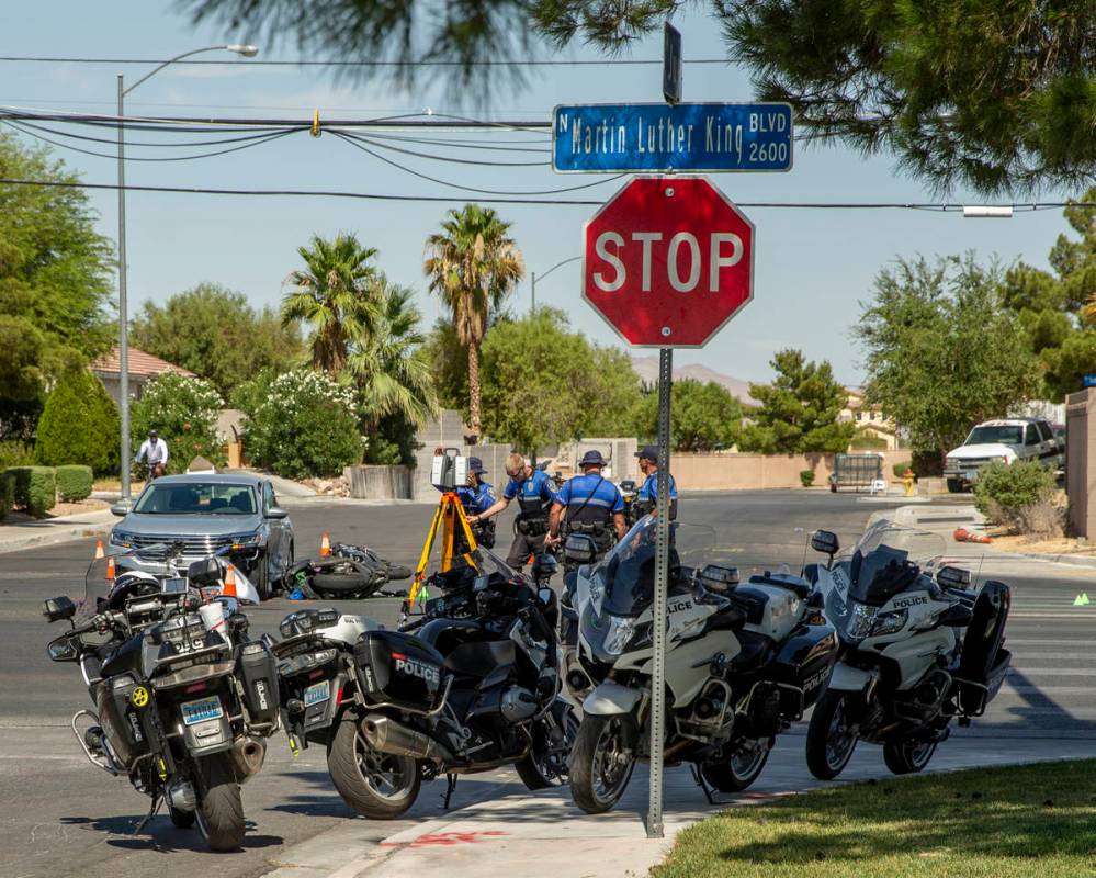 A Major Crash Investigation Unit records the scene of a downed motorcycle and car collision as ...