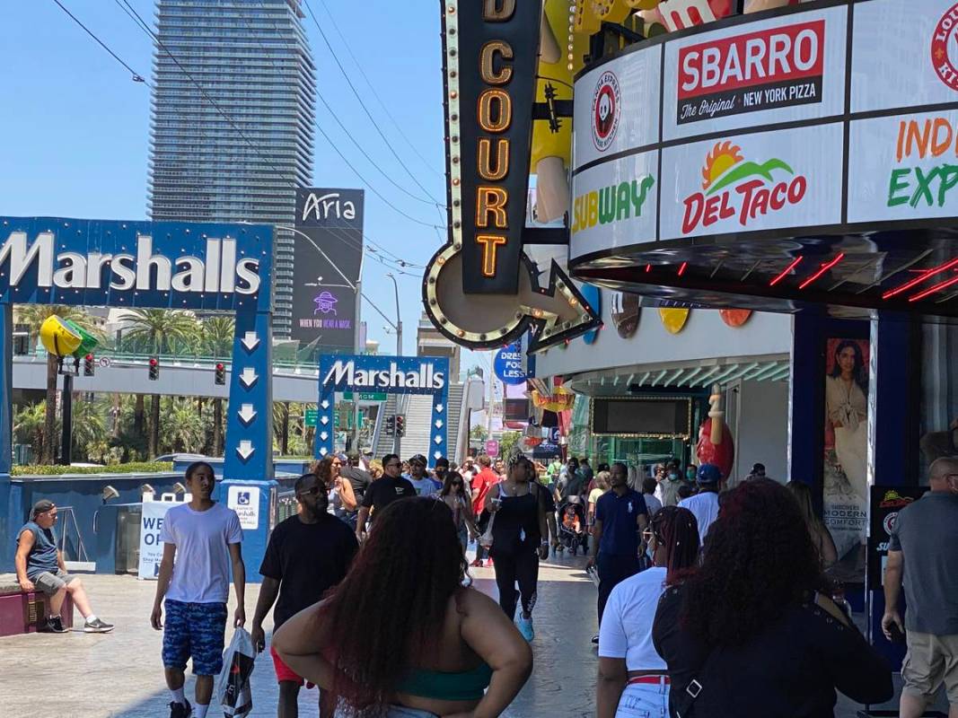 A busy sidewalk in front of the Showcase Mall near the MGM Grand sees very few guests wear mask ...