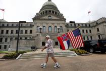 Don Hartness of Ellisville, walks around the Capitol carrying the current Mississippi state fla ...