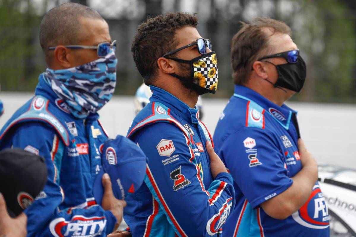 Bubba Wallace, center, stands with his crew during the playing of the national anthem before a ...