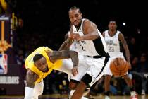 Los Angeles Lakers' LeBron James, left, and Los Angeles Clippers' Kawhi Leonard (2) chase the b ...