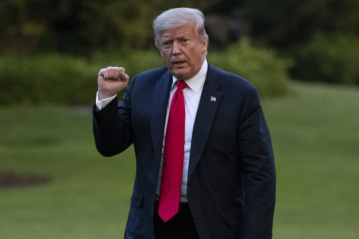 President Donald Trump pumps his fist as he walks on the South Lawn after arriving on Marine On ...