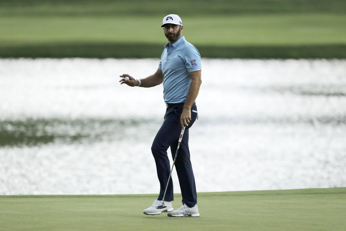 Dustin Johnson reacts after sinking his putt on the 15th green during the final round of the Tr ...