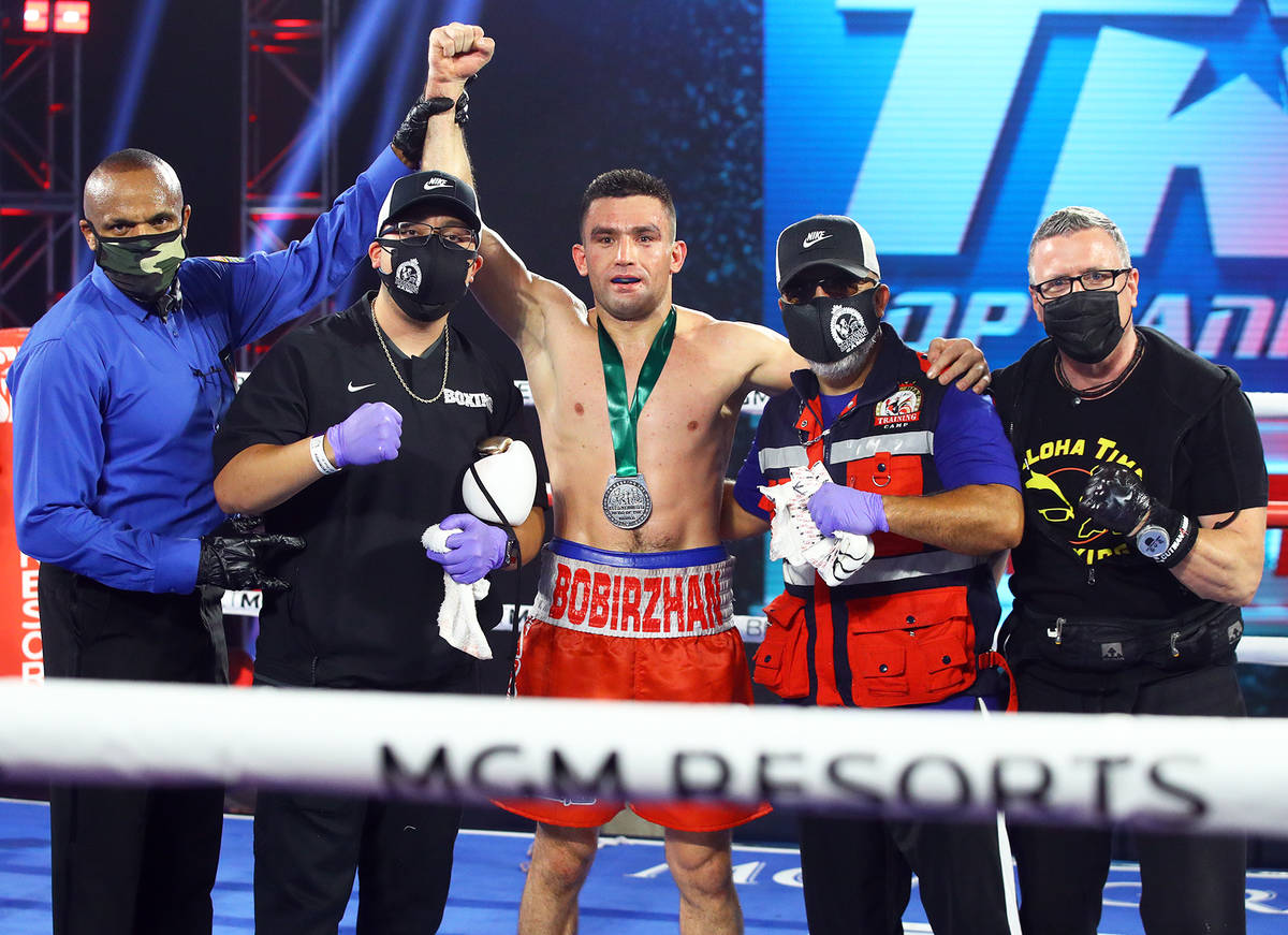 Boxer Bobirzhan Mominov celebrates with his cornermen, including Mike Bazzel (far right) after ...