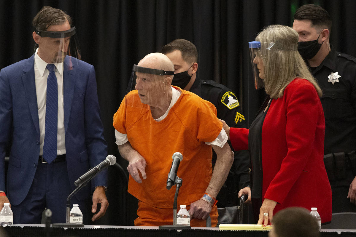Joseph James DeAngelo, center, charged with being the Golden State Killer, is helped up by his ...