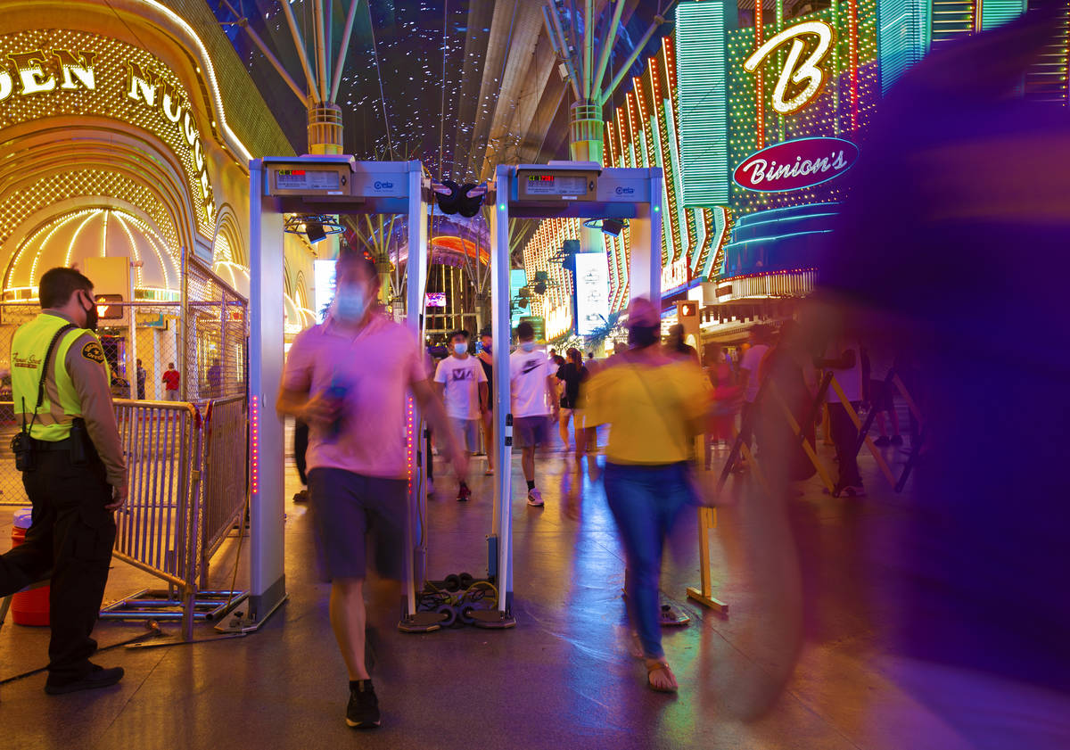 Visitors pass through scanners that read temperatures and act as metal detectors at the Fremont ...