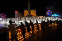 Entertainers from Mystique Showgirls watch the Fountains of Bellagio on the Strip on Wednesday, ...