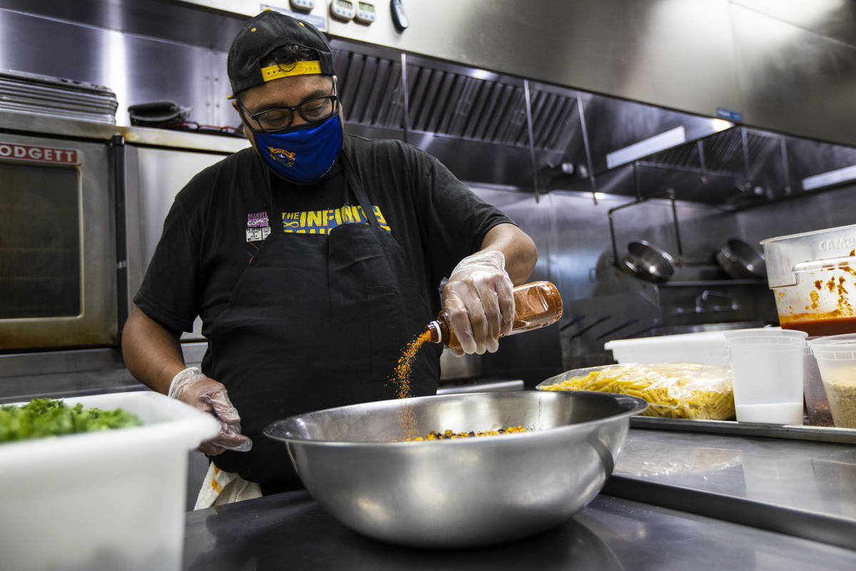Paras Shah, co-owner and co-chef at Valencian Gold, prepares meals for Delivering with Dignity ...