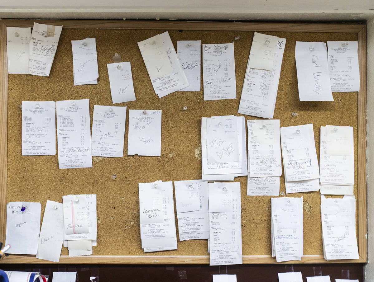 A bulletin board showing customer receipts that owner Mario Berlanga has forgiven, with the pro ...