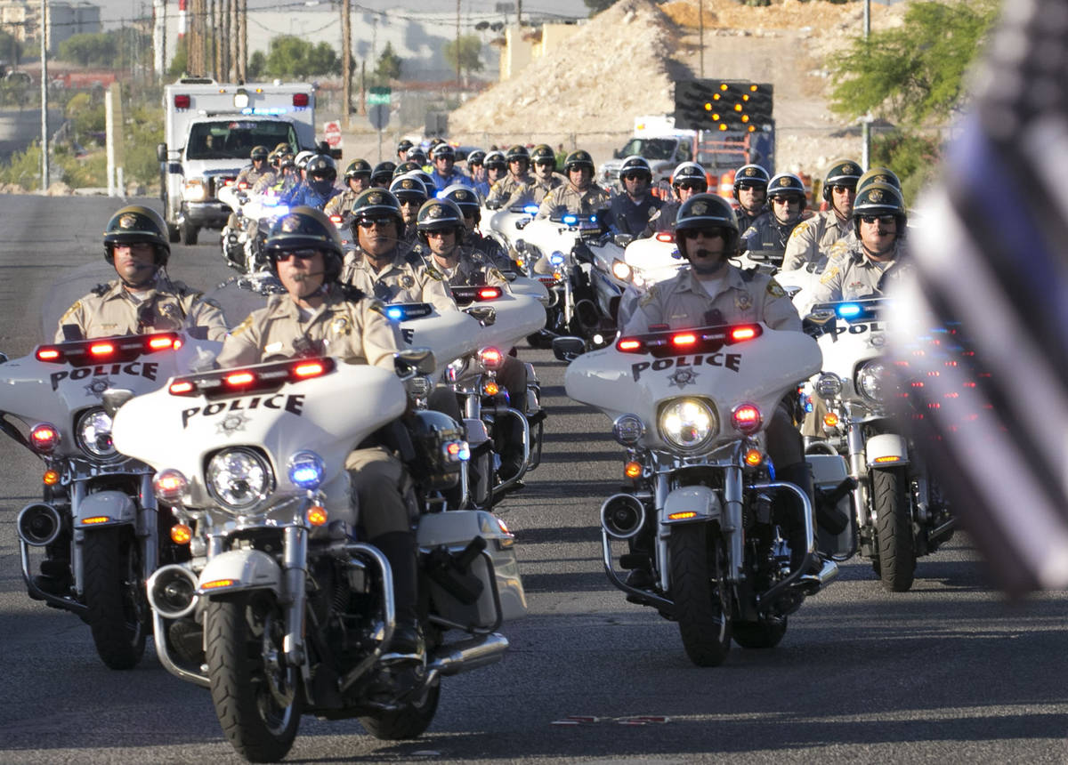 An ambulance carrying a wounded Las Vegas police officer Shay Mikalonis is seen during a proces ...