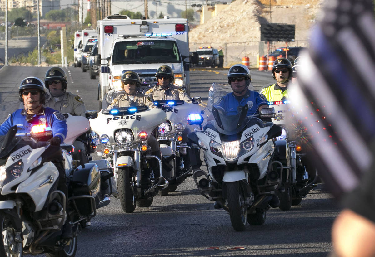 An ambulance carrying a wounded Las Vegas police officer Shay Mikalonis is seen during a proces ...