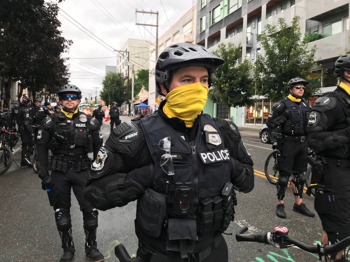 Seattle police stand on a road in the Capitol Hill Organized Protest zone early Wednesday, July ...