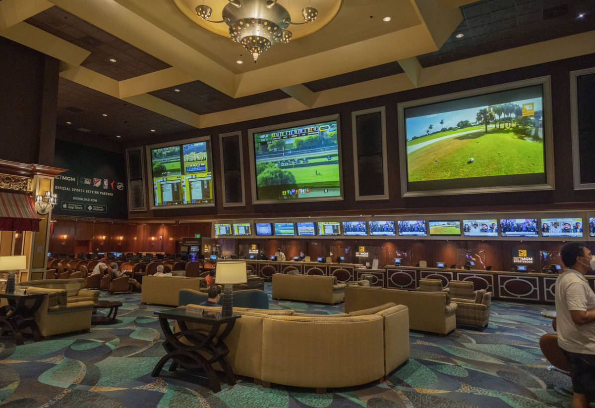 Individuals wait for a horse race to begin on the reopening of the Bellagio sportsbook, Thursda ...