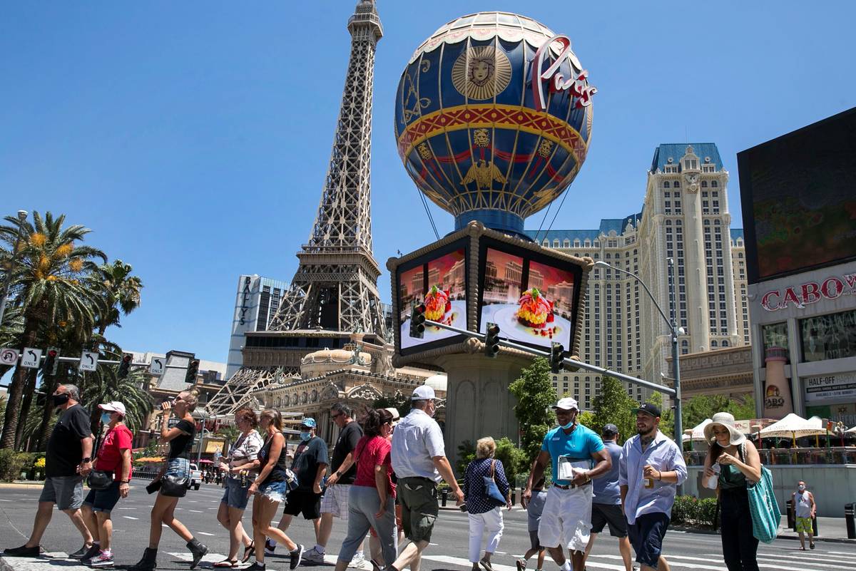 Tourists cross Las Vegas Boulevard near Paris hotel-casino on Friday, July 3, 2020, in Las Veg ...