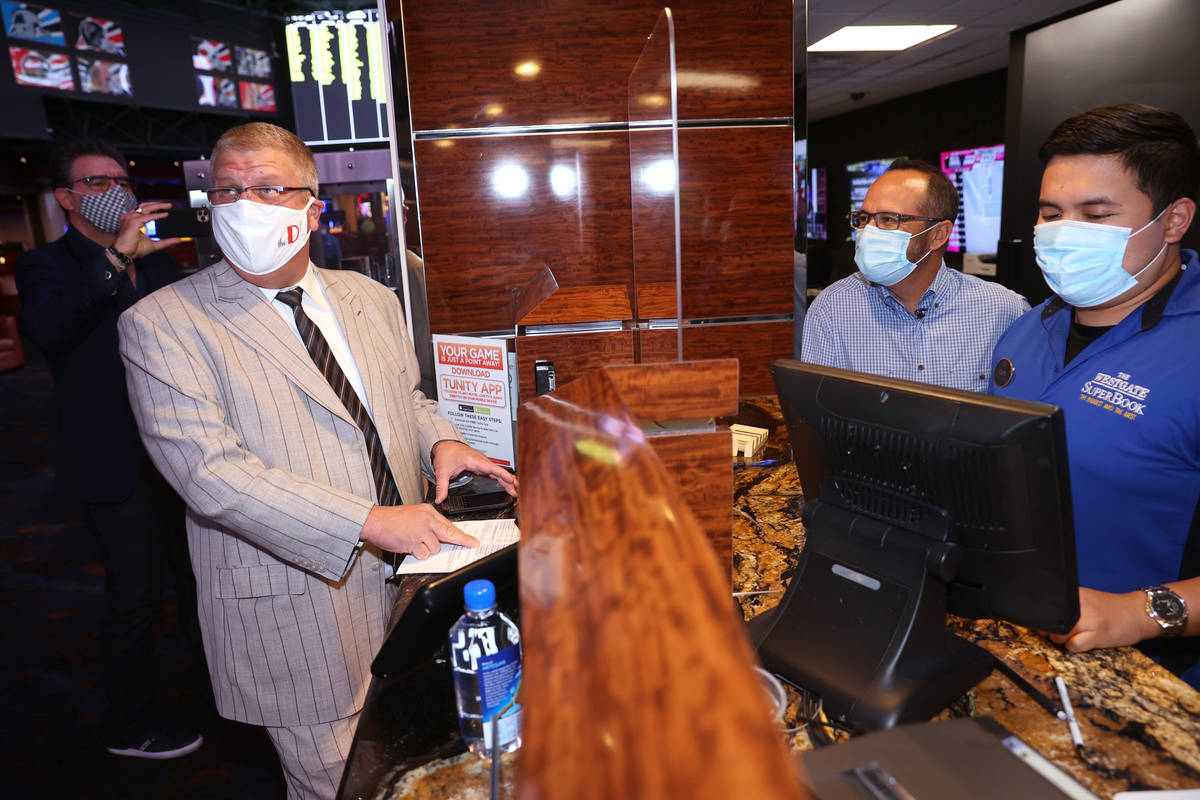Circa Las Vegas co-owner and CEO Derek Stevens checks the screens before placing a bet with Wes ...