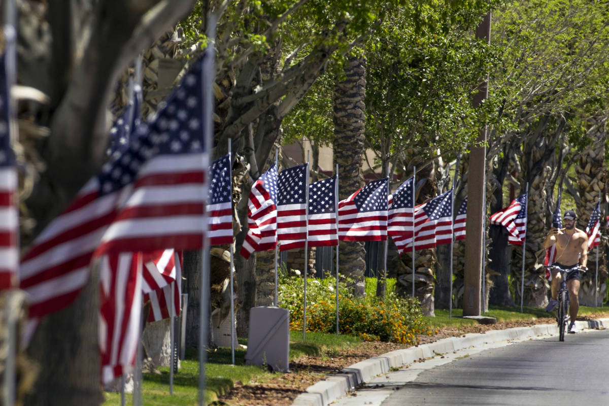 Ruben Kihuen shoots some video as he rides past the Flags Over Summerlin display along S. Town ...