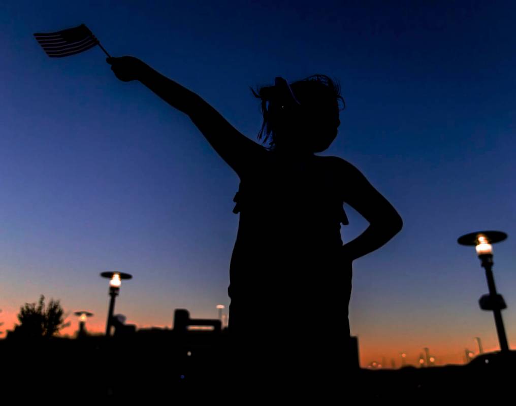 Rylee Wilkerson, 9, waves an American flag while she waits for the start of the Red Rock Casino ...