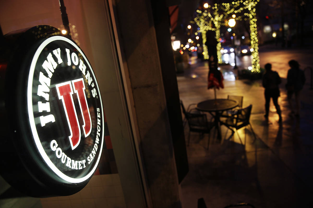 Pedestrians pass by a Jimmy John's sandwich shop, Friday, Jan. 2, 2015, in Atlanta. (AP Photo/D ...