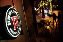 Pedestrians pass by a Jimmy John's sandwich shop, Friday, Jan. 2, 2015, in Atlanta. (AP Photo/D ...