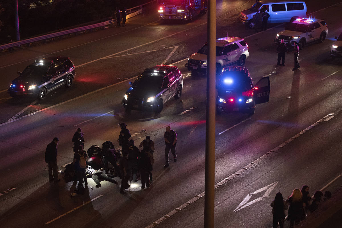 Emergency workers tend to an injured person on the ground after a driver sped through a protest ...
