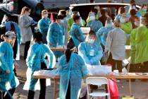 In a June 27, 2020, file photo, medical personnel prepare to test hundreds of people lined up i ...