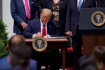 President Donald Trump signs the Paycheck Protection Program Flexibility Act during a news conf ...