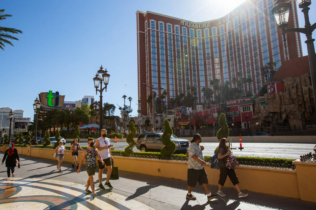 People walk down the Strip in front of Treasure Island in Las Vegas on Friday, July 3, 2020. (C ...