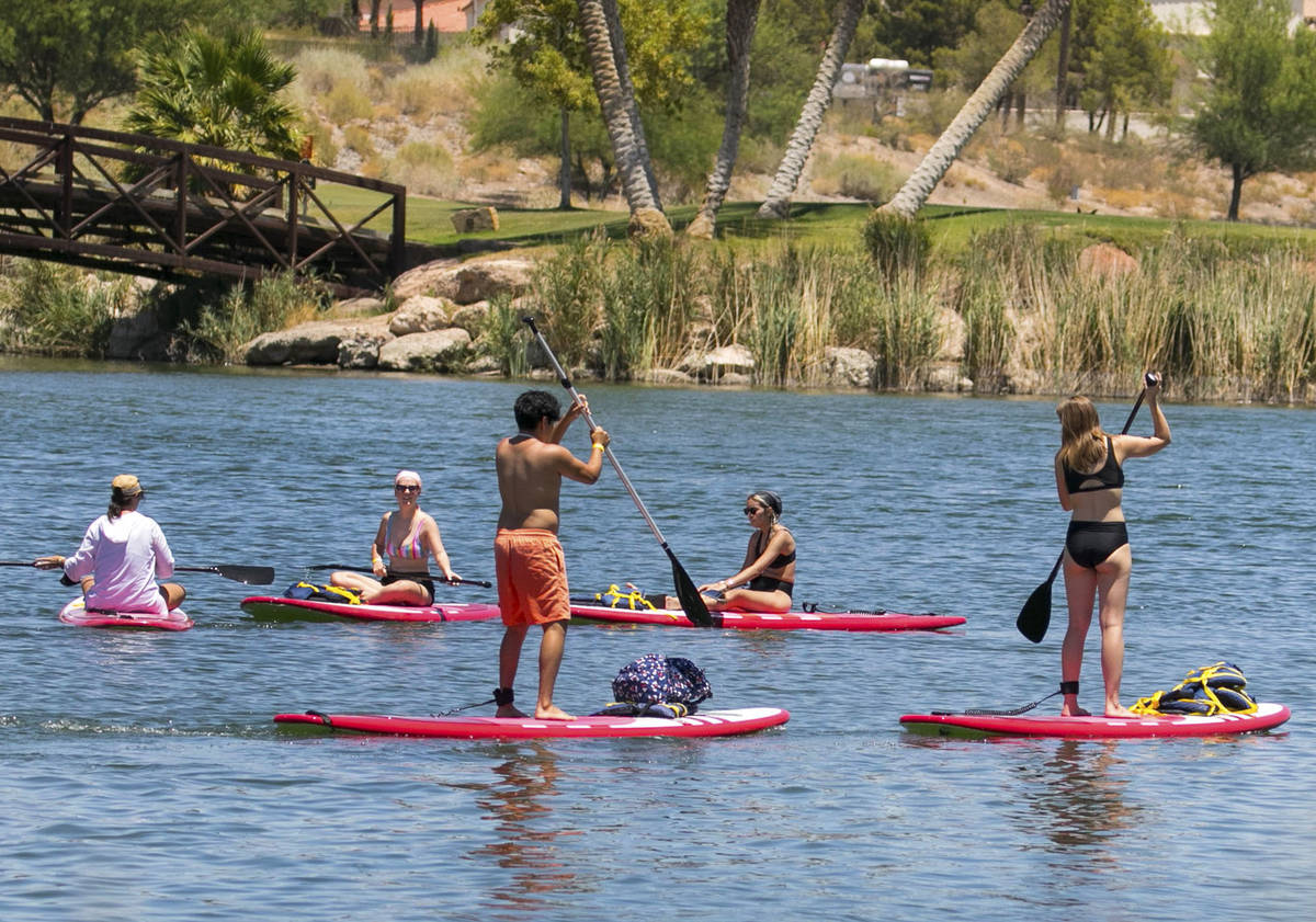 People take advantage of the hot weather to enjoy paddle boarding at Lake Las Vegas on Monday, ...