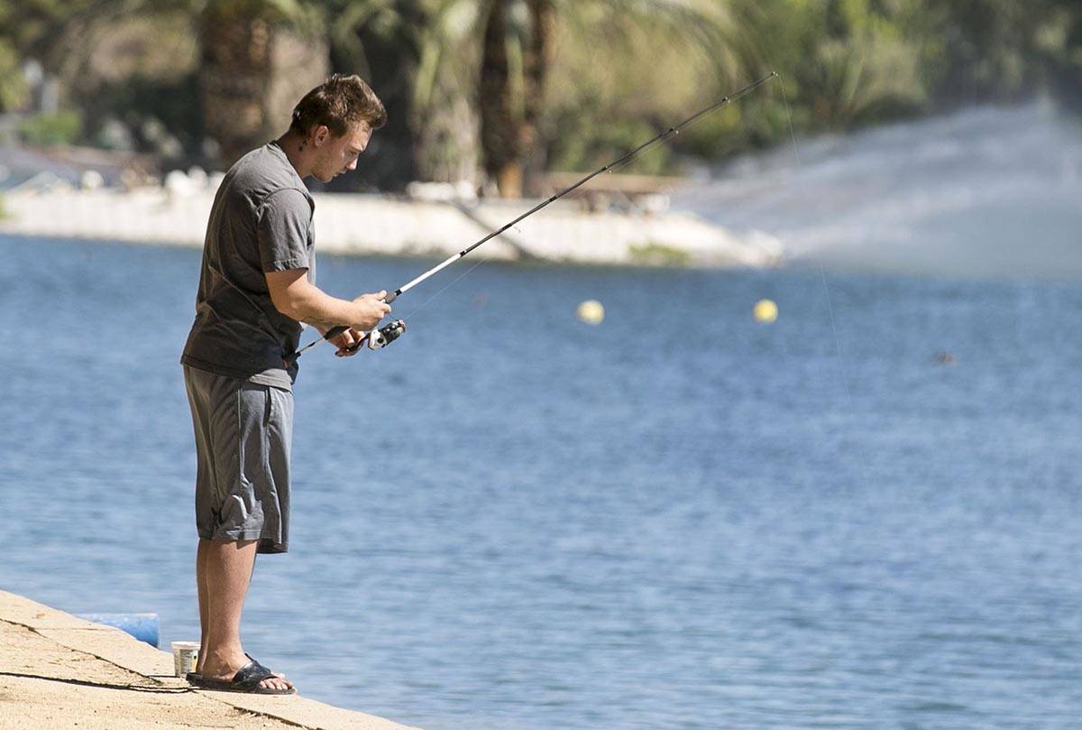 Zack Sutherland fishes at Sunset Park on Wednesday, July 8, 2020, in Las Vegas. The forecast hi ...