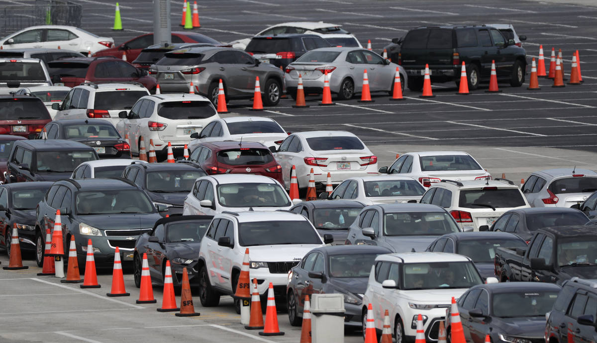 Lines of cars wait at a drive-through coronavirus testing site, Sunday, July 5, 2020, outside H ...