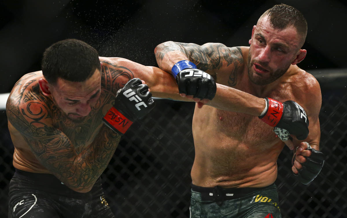 Max Holloway, left, fights Alexander Volkanovski during their featherweight title boutÊin UFC ...