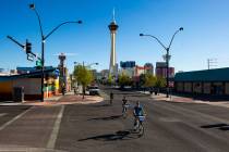 People bike down Main Street in the Arts District as traffic remains light in the wake of the c ...