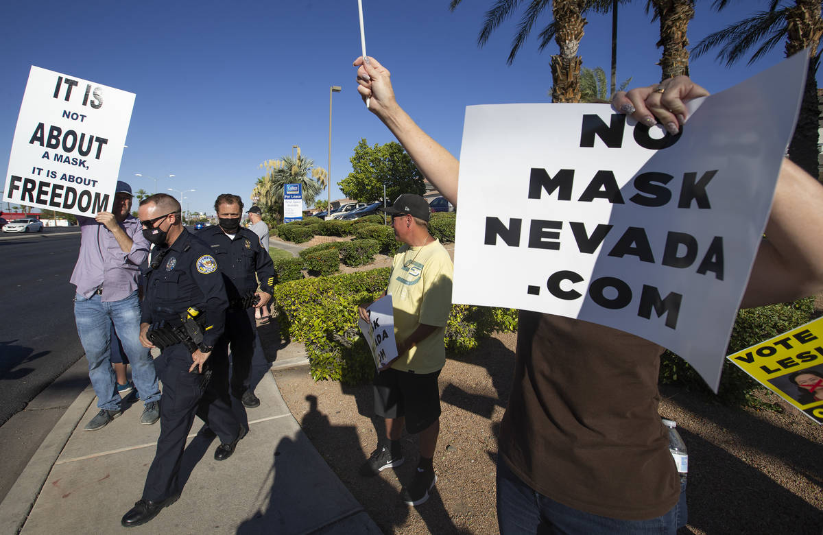 Metropolitan police donned masks as they spoke with protesters at the "No Mask Protest&quo ...