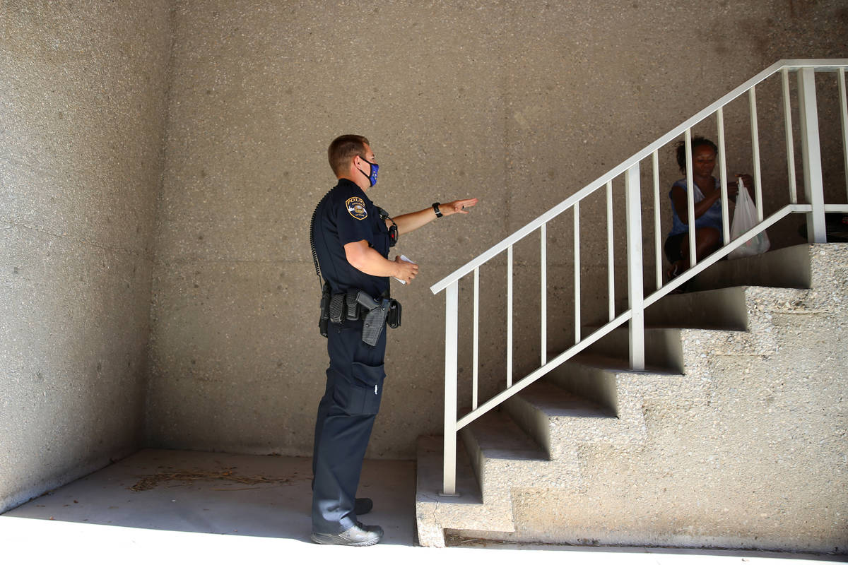 University Police Department officer Ryan Willman speaks to a homeless woman sleeping at UNLV i ...