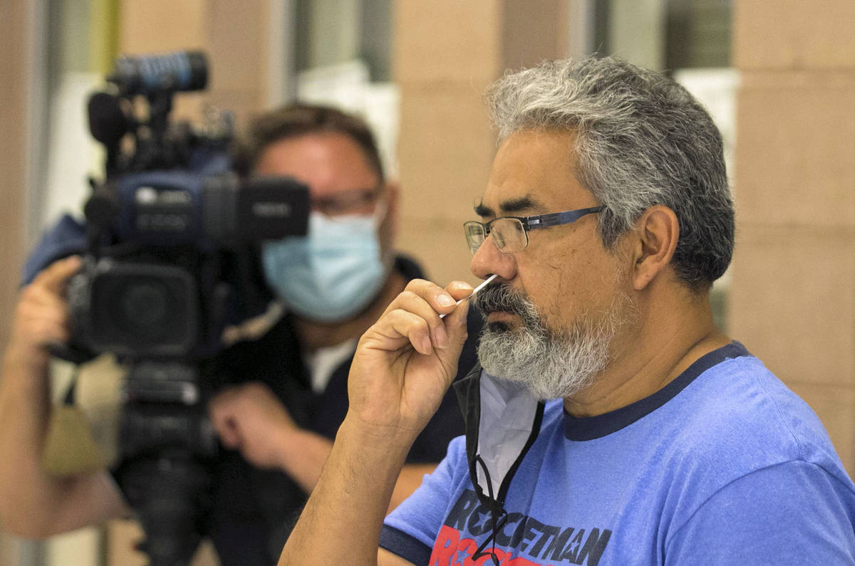 Heriberto Ramos, president of Las Vegas Migrants Club, conducts self-swabbing test during a com ...