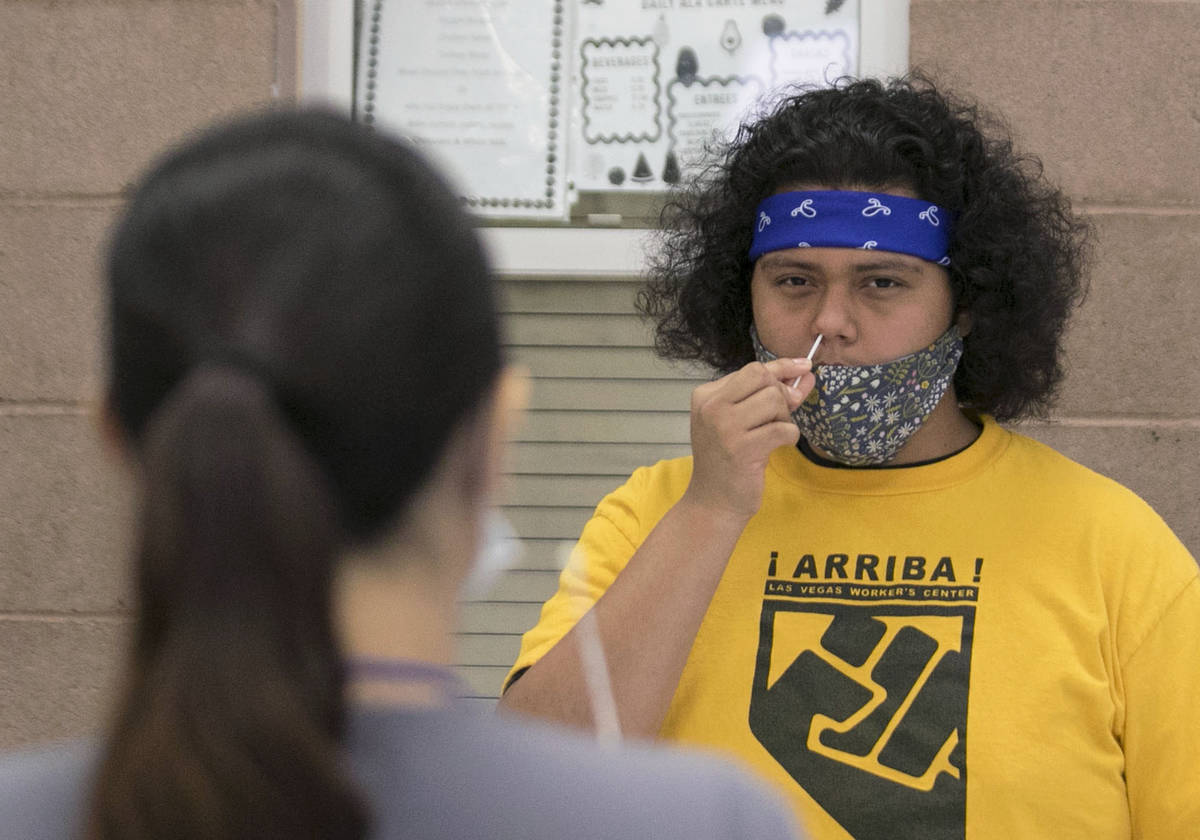 Alondra Contreras, left, a register nurse from Southern Nevada Health District, watches as Urie ...